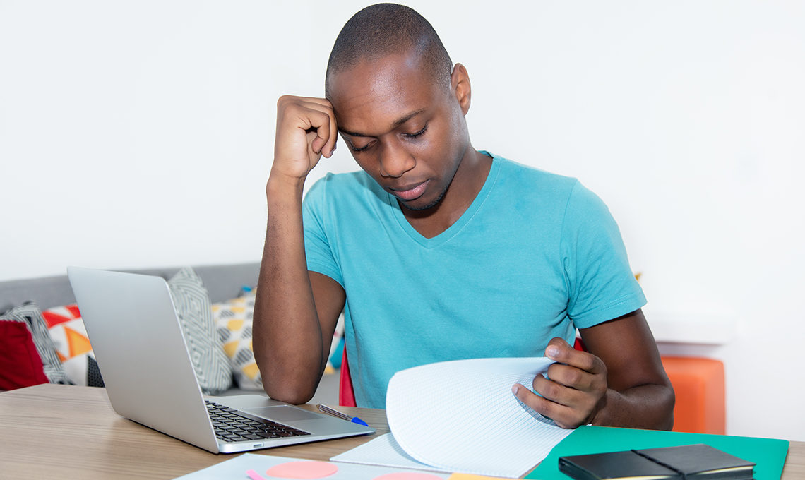 African man learning online using laptop